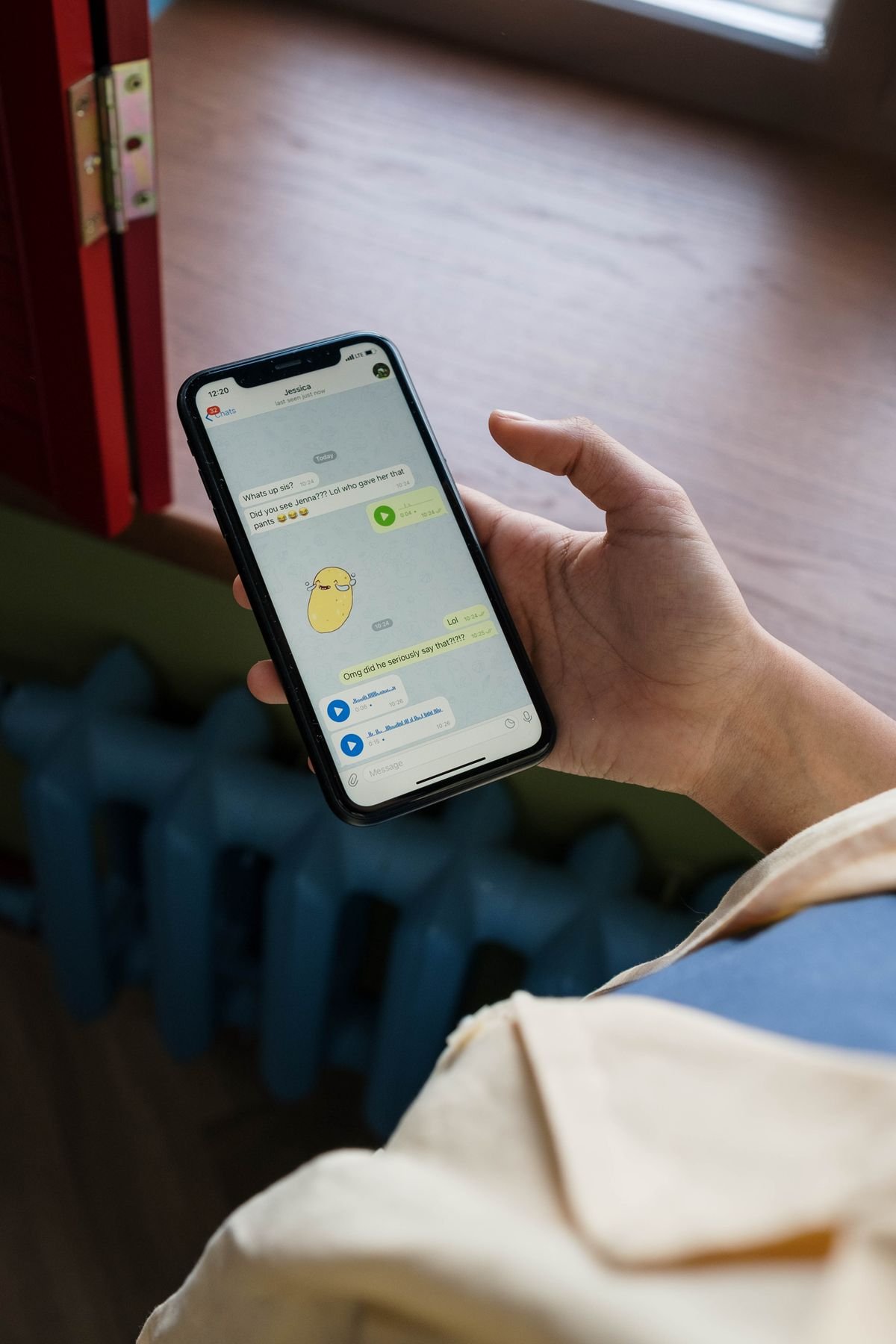 Persona sosteniendo un smartphone con una aplicación de mensajería abierta